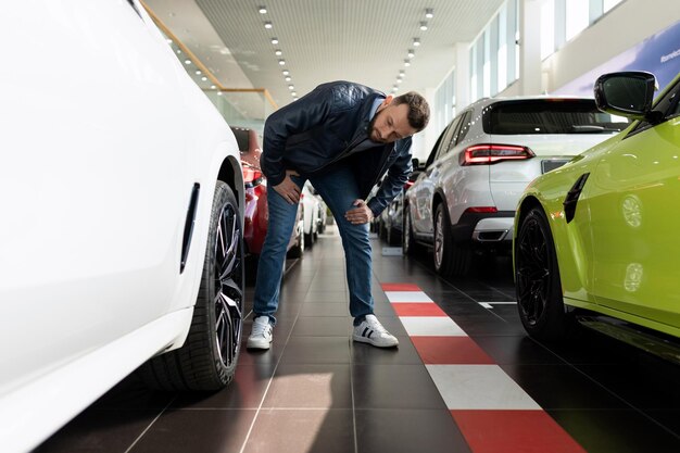 A man in a car dealership chooses new tires and alloy wheels for his car