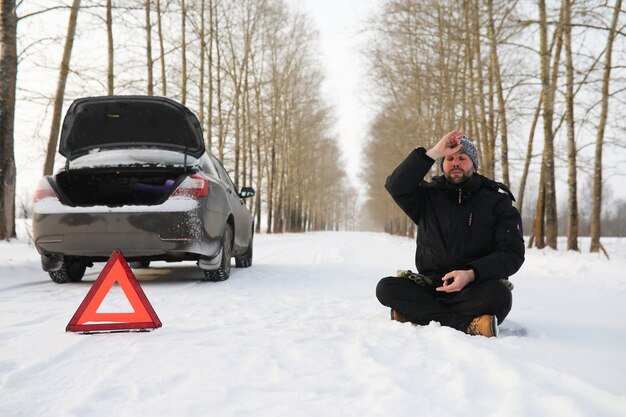 Photo man and car. winter road walk and car repair.