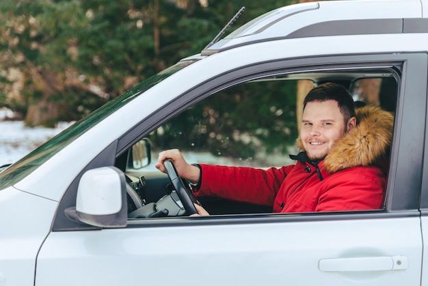 カメラを見て冬の時間に車の中で男