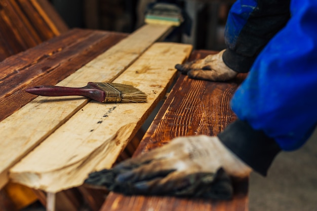 Человек плотник цвет коричневая краска деревянная планка в своей домашней мастерской