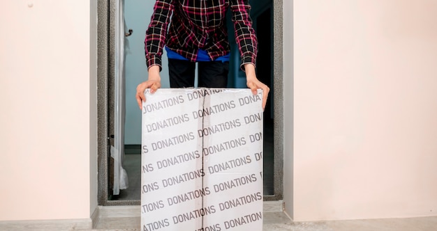 A man carry the donation box to give it to children as charity, human help and assistance