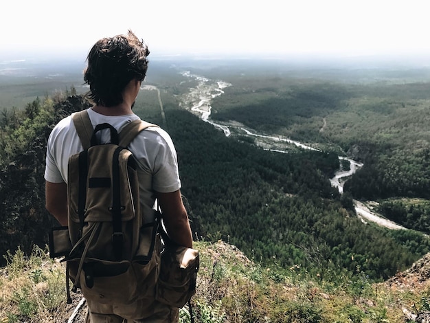 man carrying backpack while looking at view