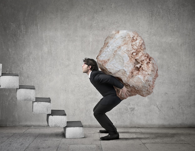 man carrying a big stone