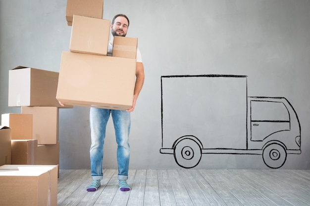 Photo man carrying boxes into new home. moving house day and express delivery concept