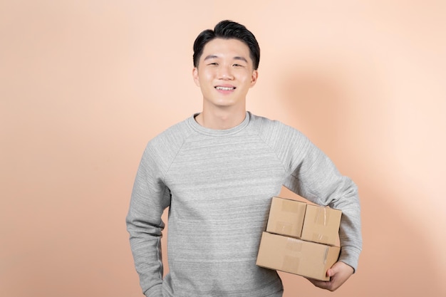 Man carrying boxes smiling on beige background