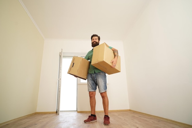 Photo man carrying cardboard box on moving day delivery man loading cardboard boxes for moving to an apartment