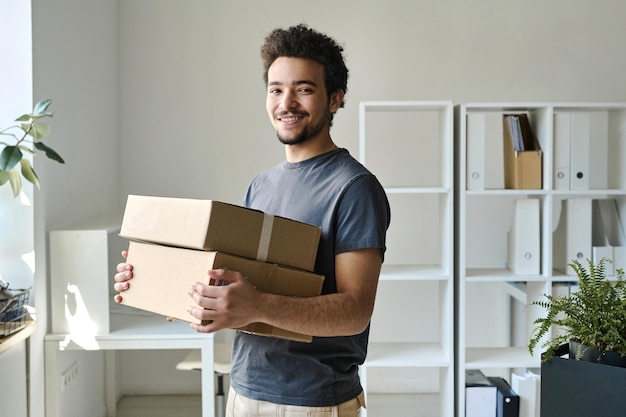 Uomo che porta scatole confezionate in ufficio