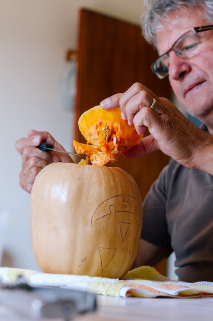 man carving een pompoen