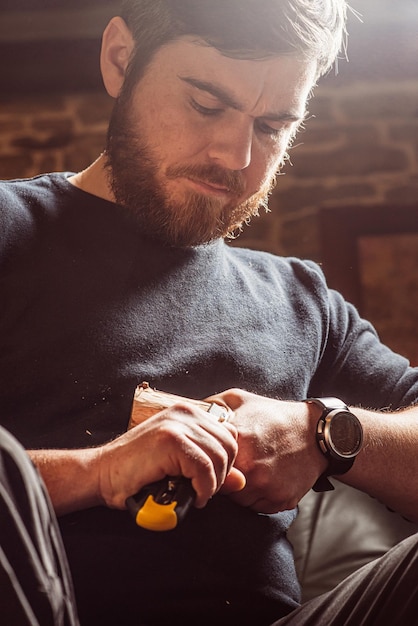 Man carving from a wooden block with a knife