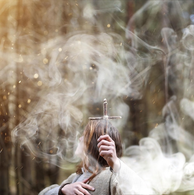 A man in a cassock spends a ritual in a dark forest