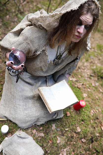 A man in a cassock spends a ritual in a dark forest