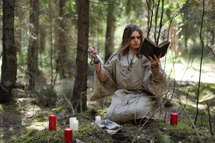 फोटो a man in a cassock spends a ritual in a dark forest