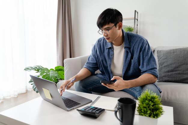 Photo the man in casual clothes working with a laptop computer smart phone calculator