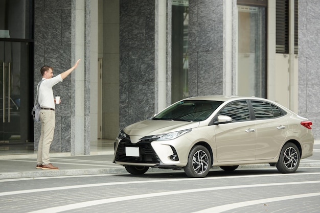 タクシー車を捕まえる男