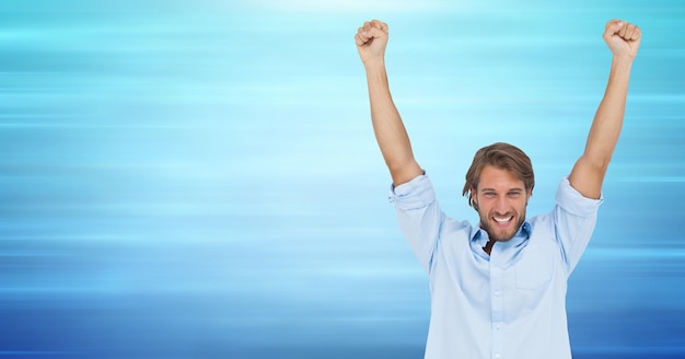 Man celebrating against blurry blue background