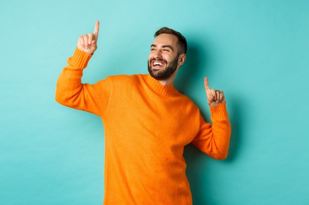 Uomo che celebra, sentendosi vincitore, puntando il dito verso l'alto e ballando campione, in piedi