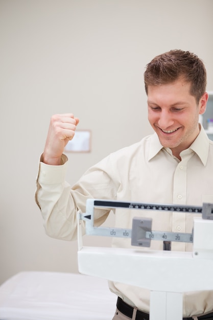 Man celebrating his victory over the scale