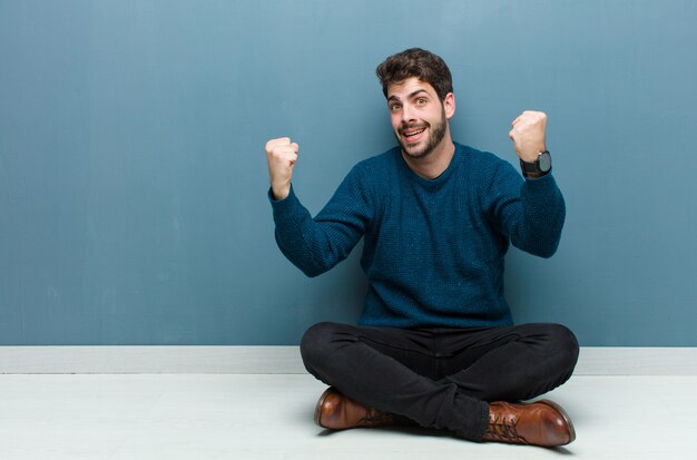 man celebrating an unbelievable success like a winner, looking excited and happy saying take that!