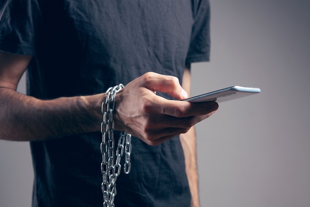 A man in chains holding a phone