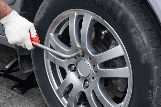 A man changes the car summer tires for winter