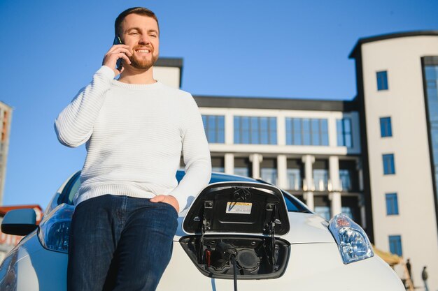 Man charges an electric car at the charging station