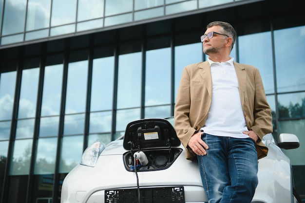 Man charges an electric car at the charging station