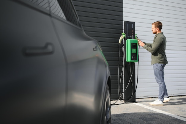 a man charges an electric car