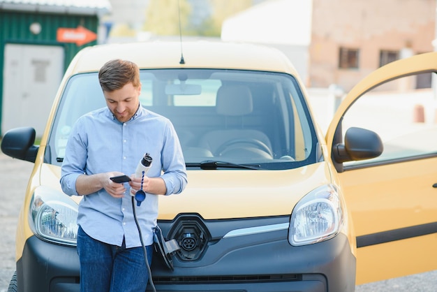 Uomo che carica la sua auto elettrica alla stazione di ricarica