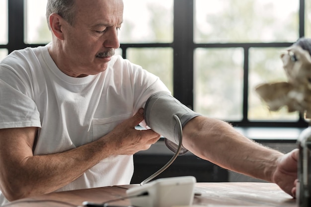 Photo man checking a blood pressure in the morning