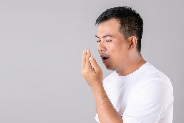 Man checking his breath with hand