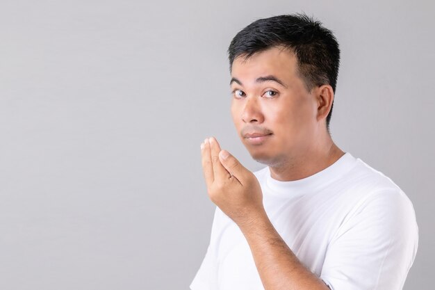 Man checking his breath with hand