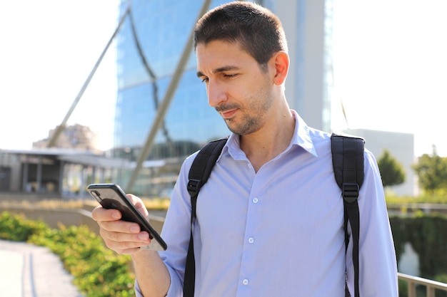 現代の都市で彼の携帯電話をチェックする男