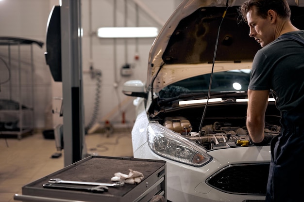 Man checking hood of car engine before a trip or journey car check condition concept rear view view ...