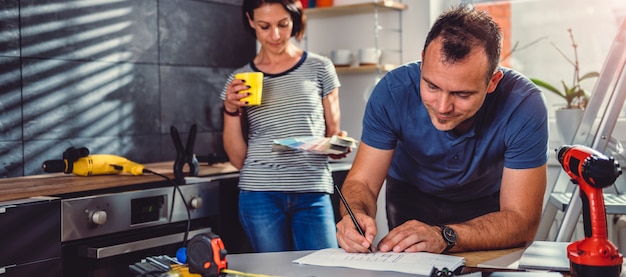 Man checking kitchen blueprints