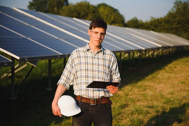 Man checking and standing near solar panels