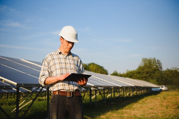 Man checking and standing near solar panels