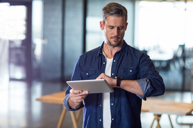 男はタブレットを押しながら時間をチェック