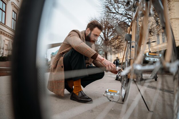 Man checking wheels on bike repairing bicycle at street