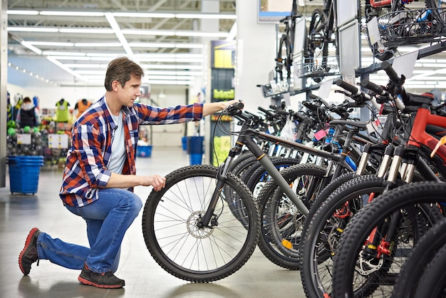 L'uomo controlla la bici prima di acquistare in negozio