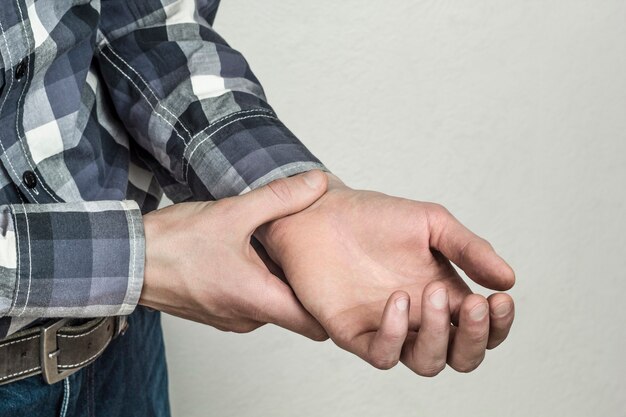 Foto un uomo controlla il polso sulla sua mano. pressione sanguigna interrotta.