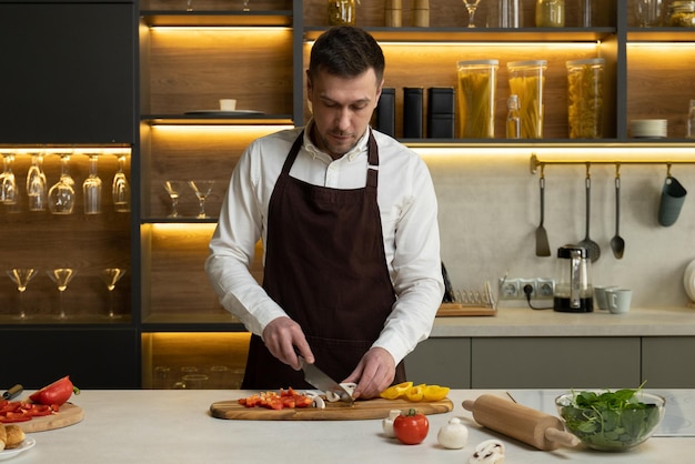 Man chef-kok in schort vertelt over kookschotel met groenten