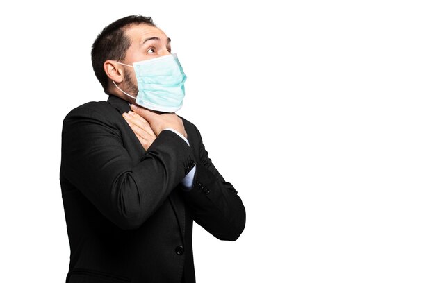 Photo man choking due to the lack of air isolated on white and wearing a mask, coronavirus concept