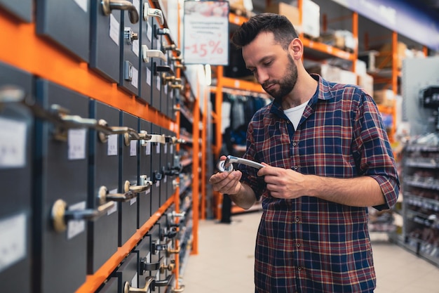 A man chooses a doorknob in a hardware store