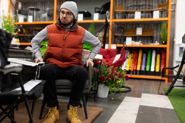 A man chooses a garden chair in a household supply store