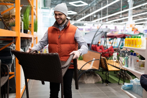 Man chooses garden furniture in a hardware store