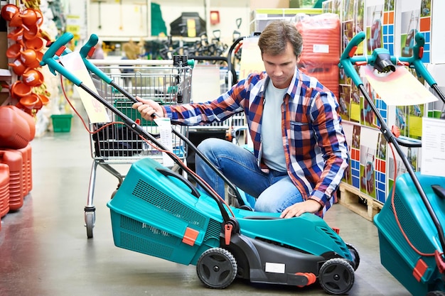 Photo man chooses lawn mower in store