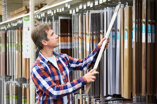 Man chooses metal plates for thresholds in a store