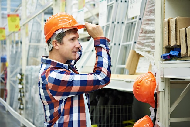 Man chooses a protective helmet in store