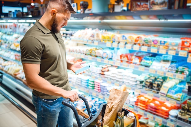 Man choosing dairy products in grocery store