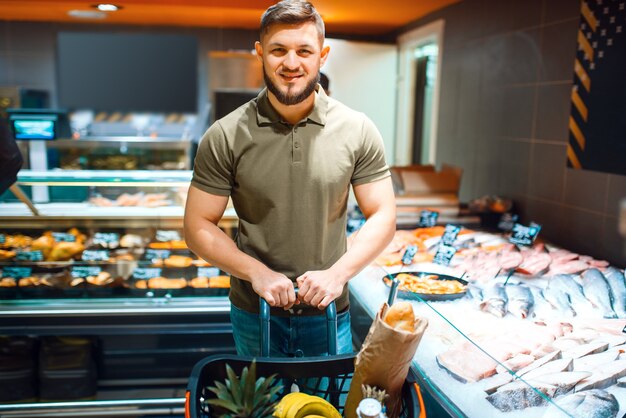Man choosing fresh chilled fish in grocery store